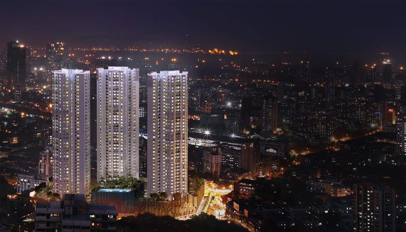 The three Ekta Tripolis towers lit at night over the Goregaon West skyline